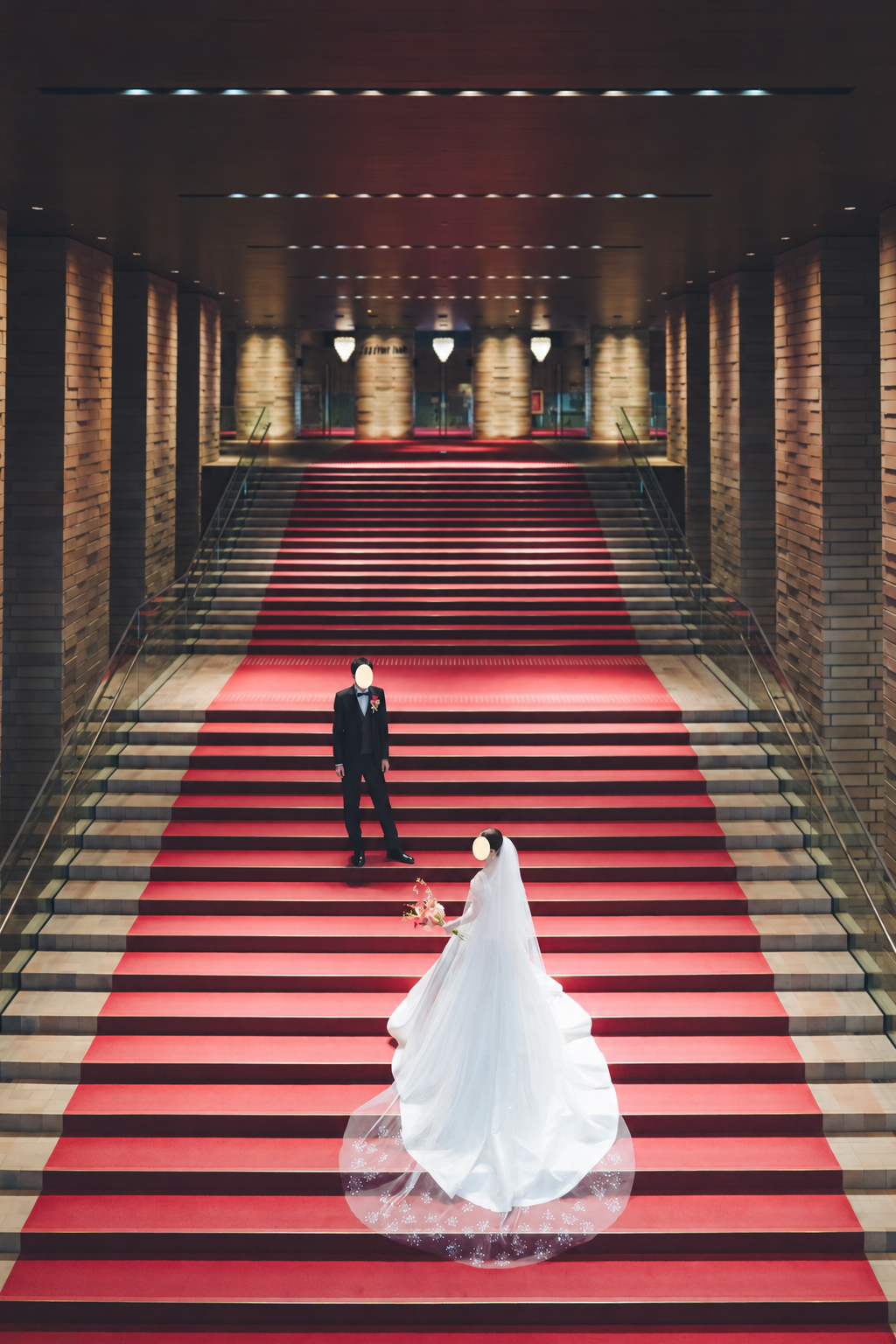 赤い大階段で撮影した新郎新婦。顔を隠した写真